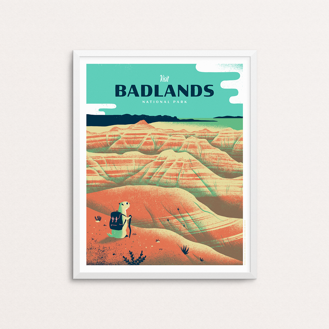 Badlands National Park screenprinted poster print. It features South Dakota, black foot ferret, Bear Butte and the Black Hills. The print is show in a white frame.