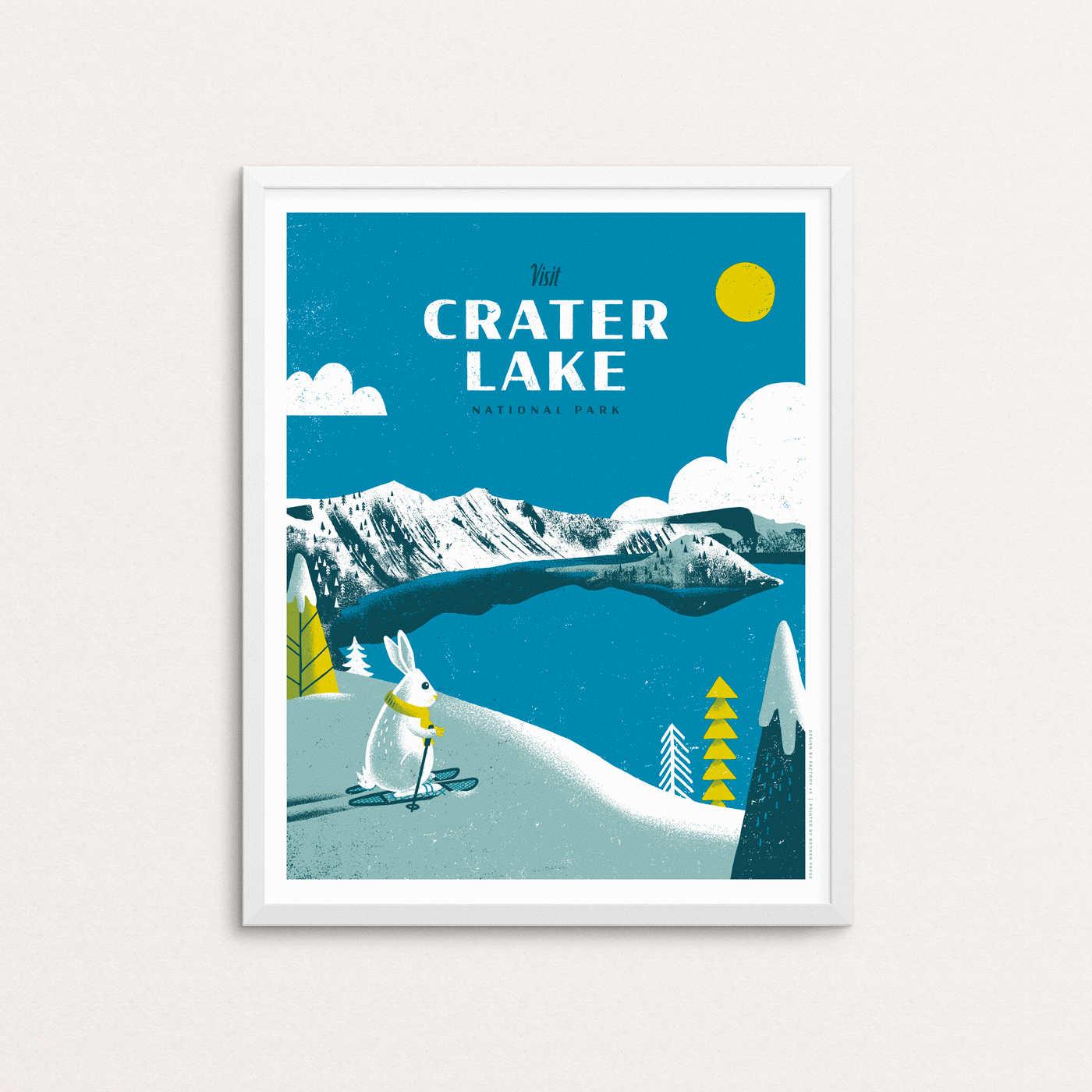 Crater Lake National Park showing a snow bunny skiing looking at Wizard Island. The Oregon caldera filled in when Mount Mazama collapsed. Photo show print in a white frame.